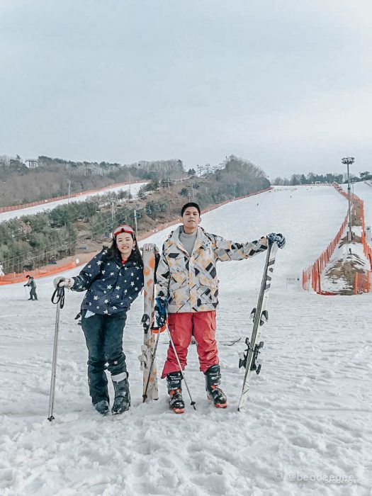 A couple with their ski equipment in the foot of a Vivaldi Ski World slope